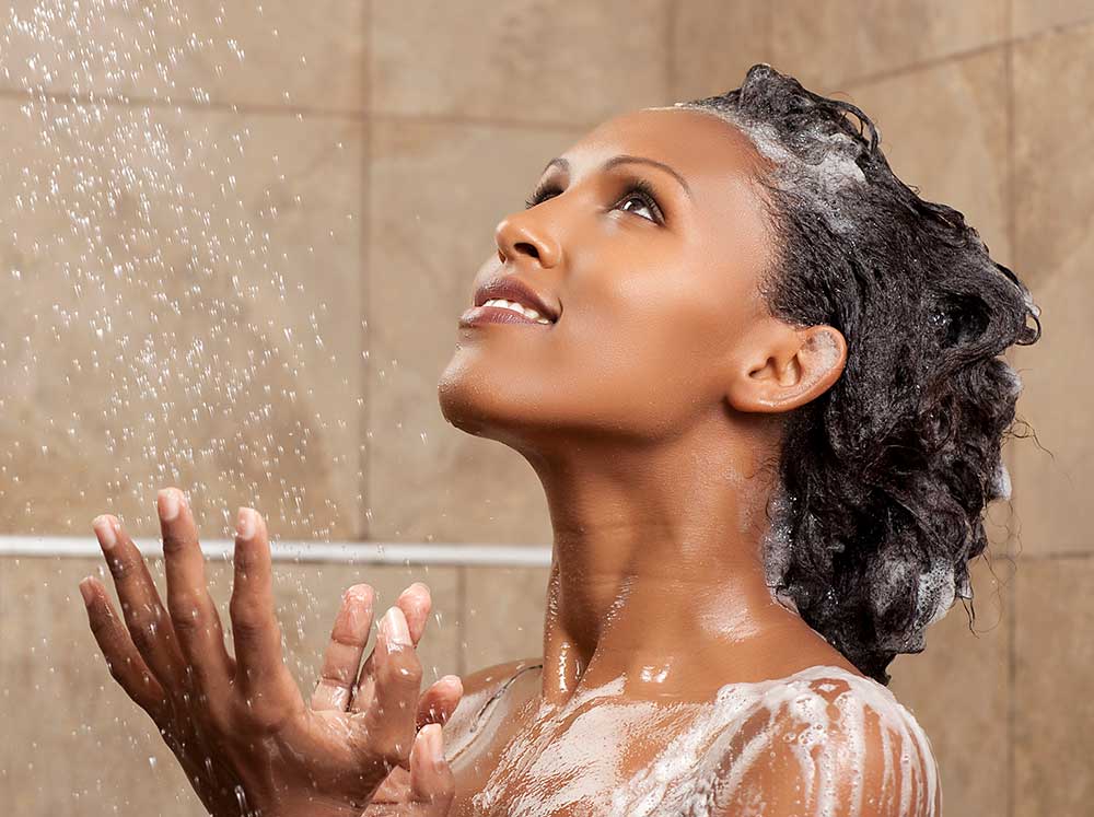 Woman in the shower washing her natural hair after having used molasses for 6 months as the Healthy Natural Hair Growth product at naturalhairzone.com