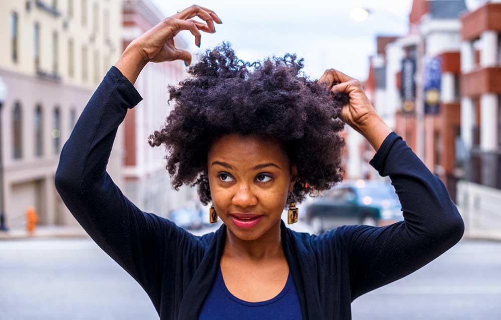 naturals lady holding hand by her head, with low porosity hair at wtgh