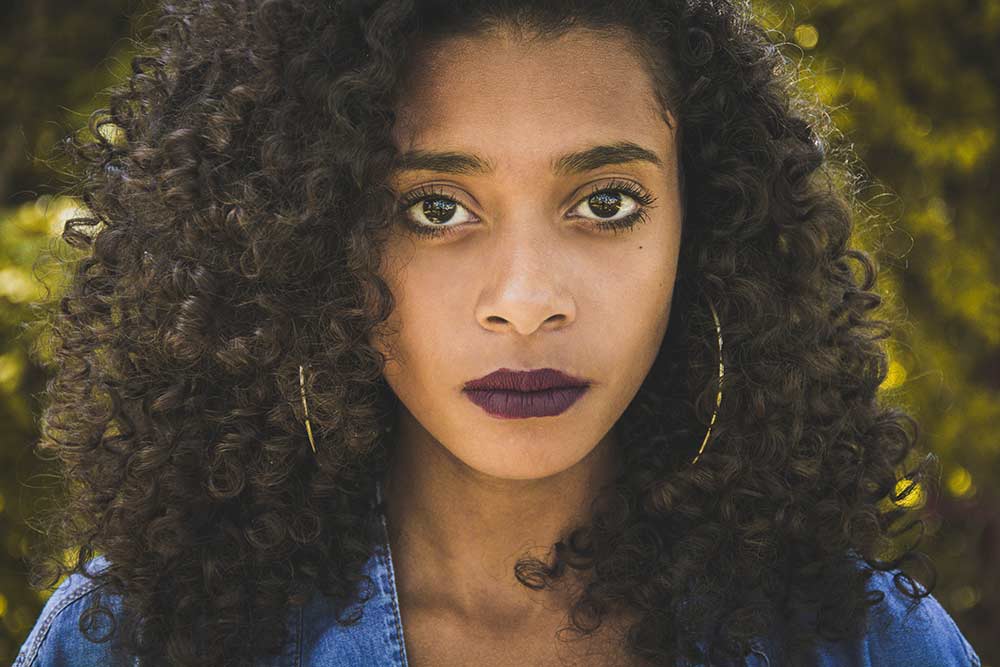 An African American womans portrait with natural 3C hair type