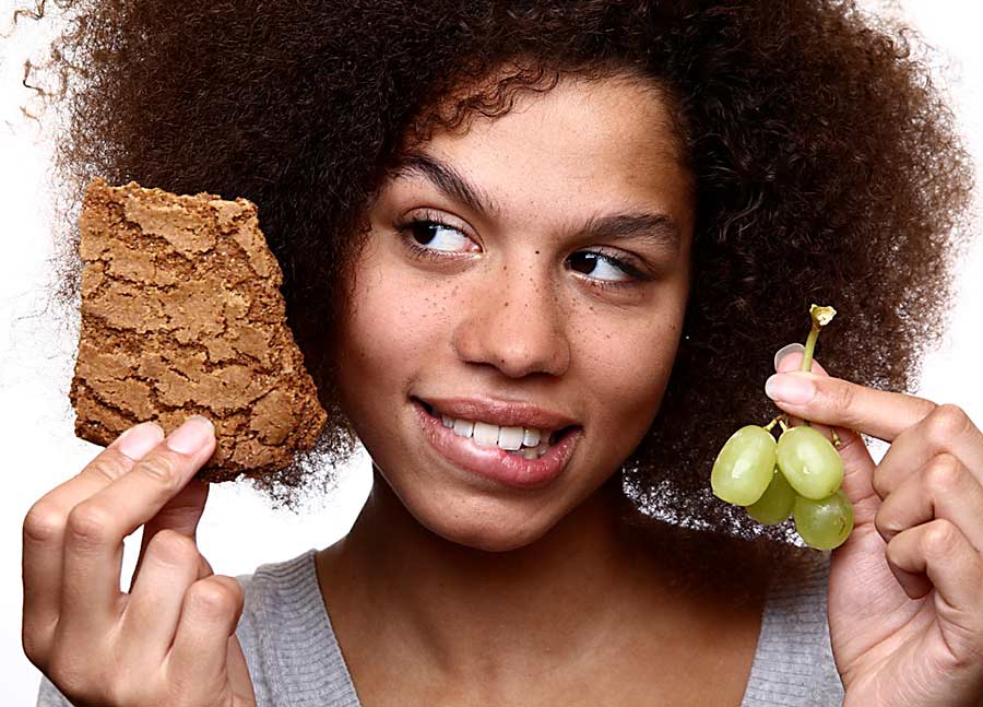 african lady holding grapes with natural hair