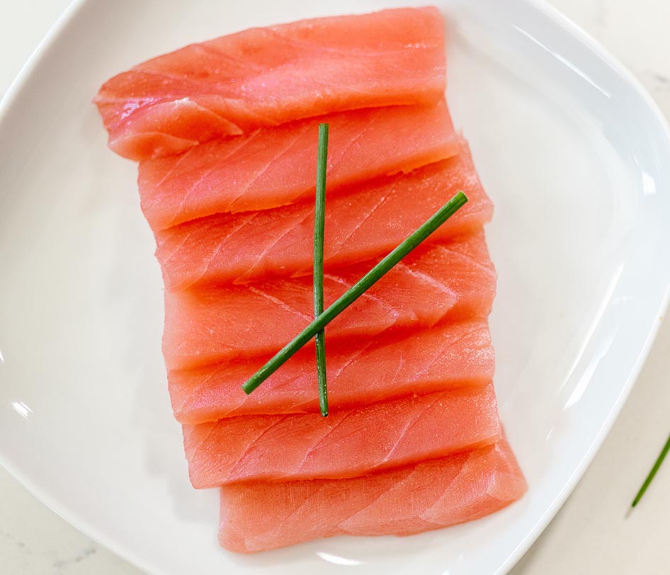 Salmon on a white plate, with some chives to help hair growth and restore iron levels