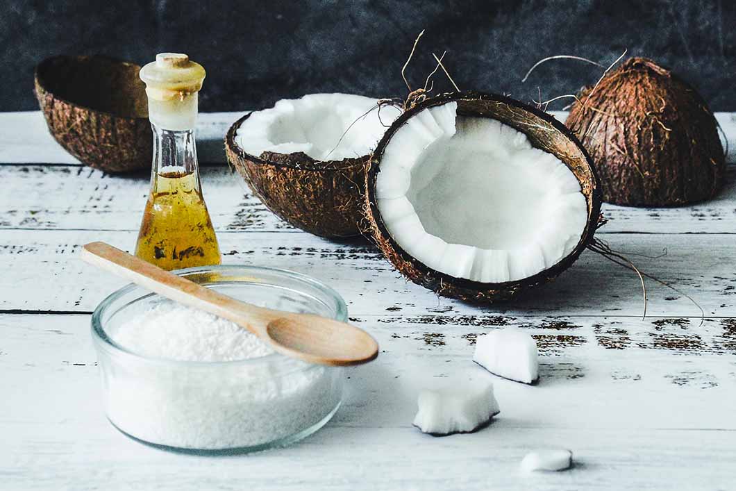 Coconut oil in a jar next to split coconut husk