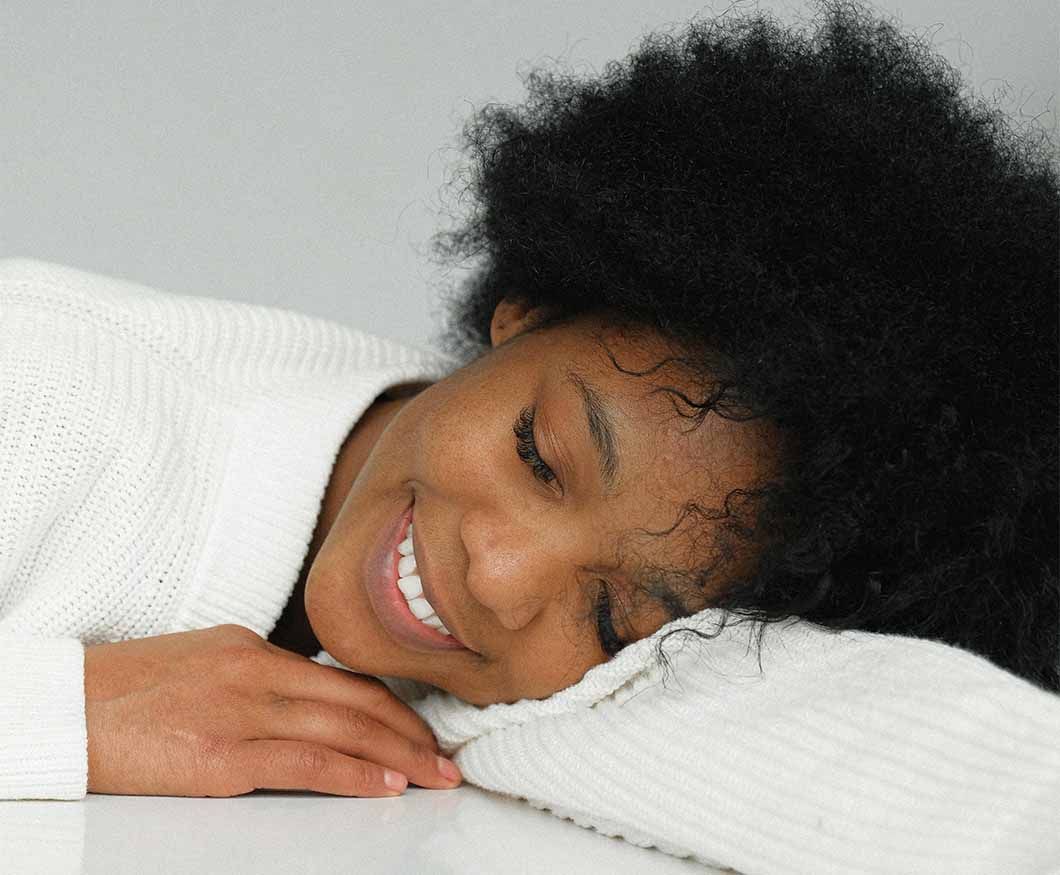 Girl with natural hair showing that one needs to sleep on satin pillows