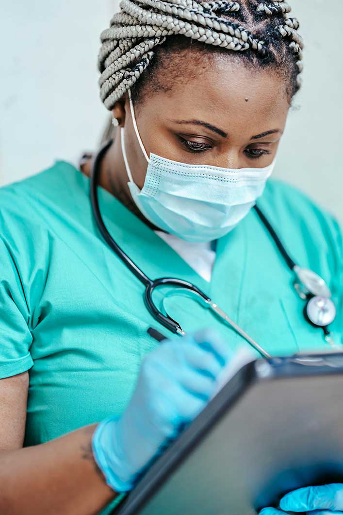 A trichologist wearing a mask and holding a clipboard with notes on thinning hair