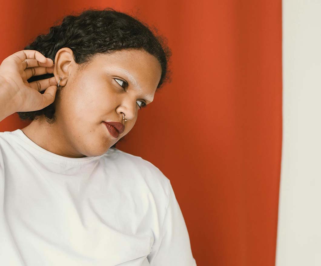 Girl with 3c hair type tucking her hair behind her ears