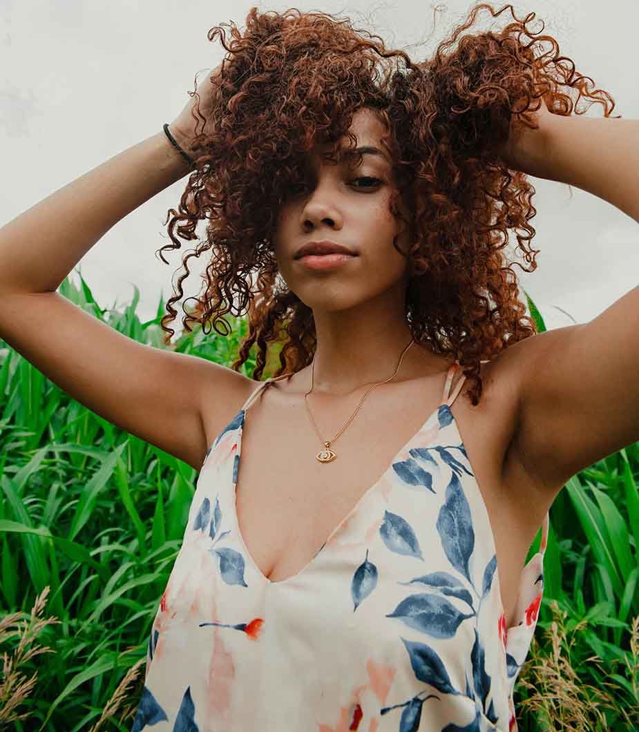 Woman with curly hair scratching her itchy scalp