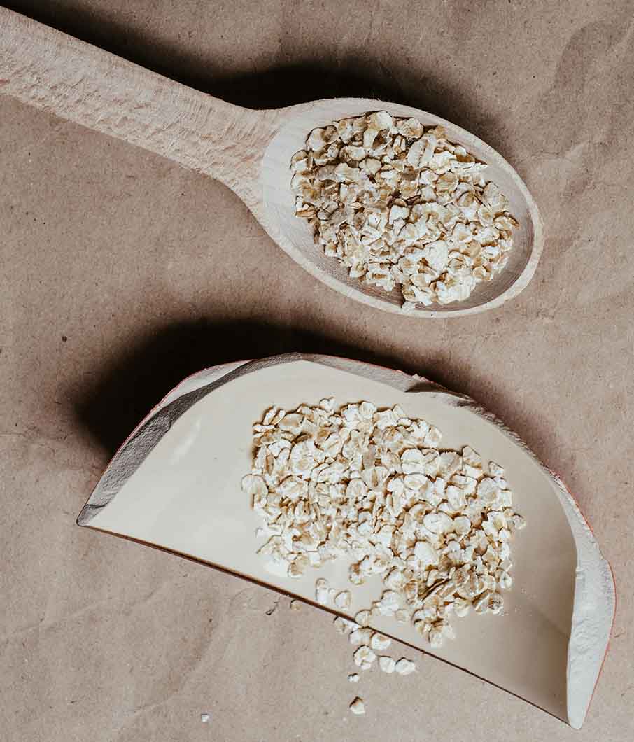 Oatmeal on a spoon that can be used to treat dry scalp conditions