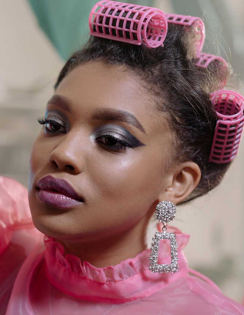 Woman with rollers on her head to curl synthetic hair