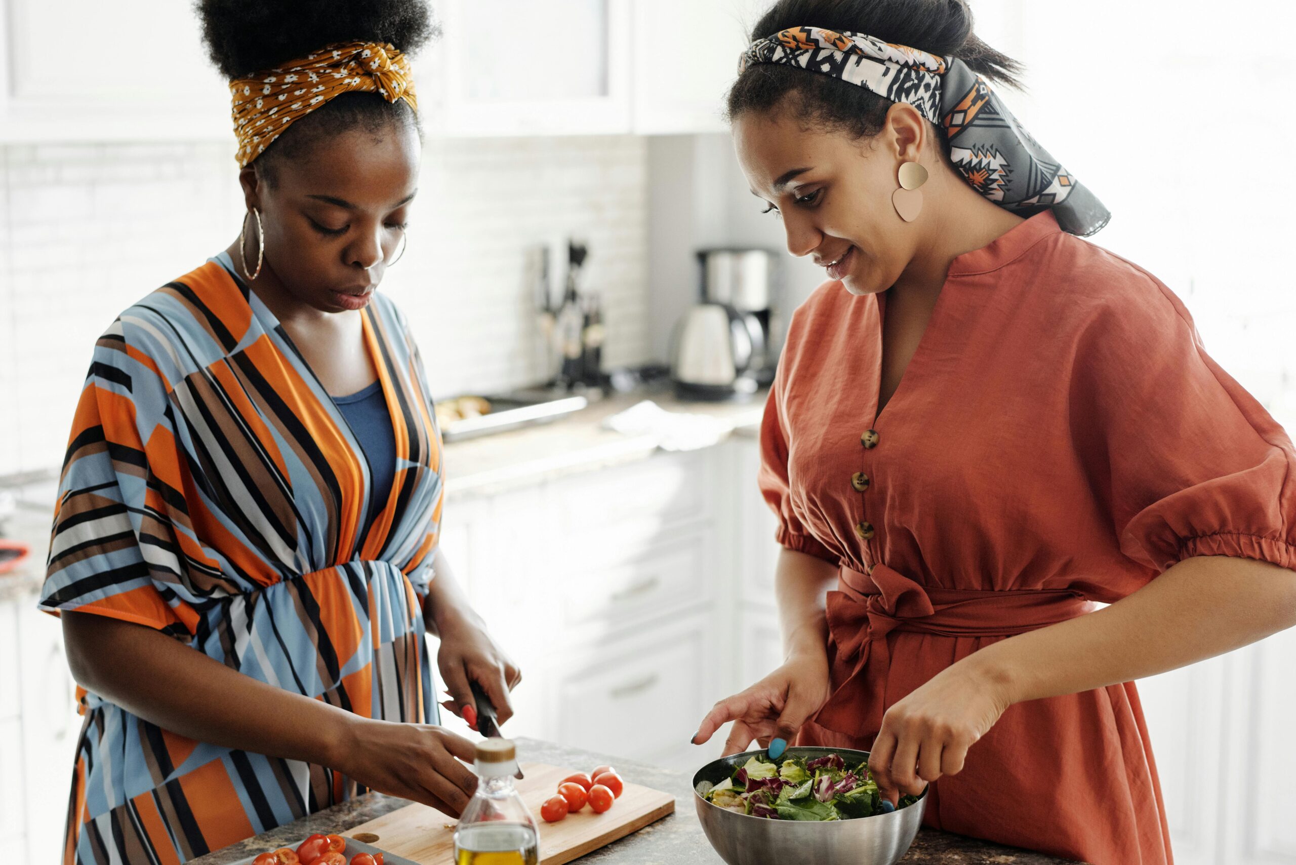 Two girls with natural hair making spinach and apple salad to combat hair loss