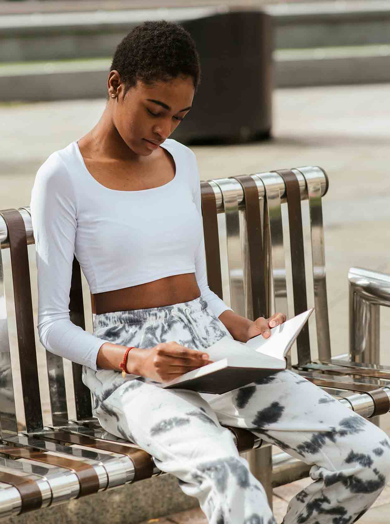 Girl on a back bench looking at her journal