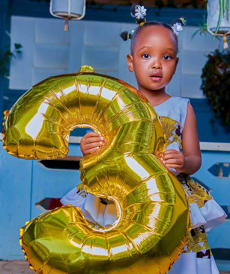 Child holding the number 3 ballon