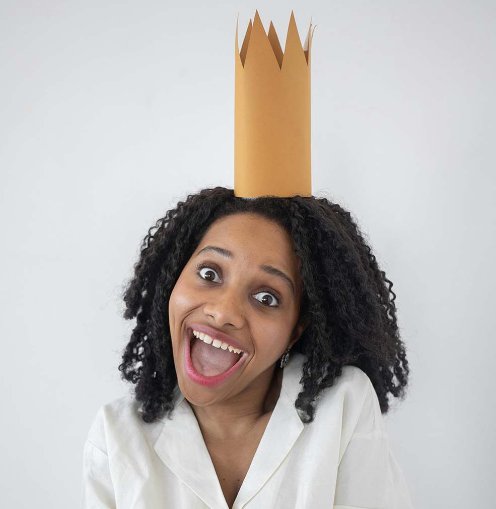 woman with paper crown on her head smiling
