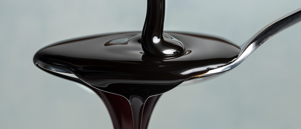 Molasses in a spoon to show benefits for hair growth