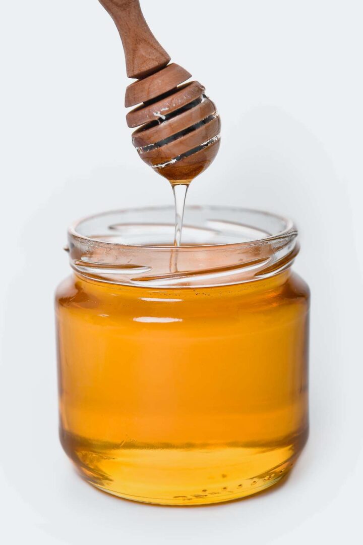 A scoop of honey from a Jar to show how honey can be used for natural hair.