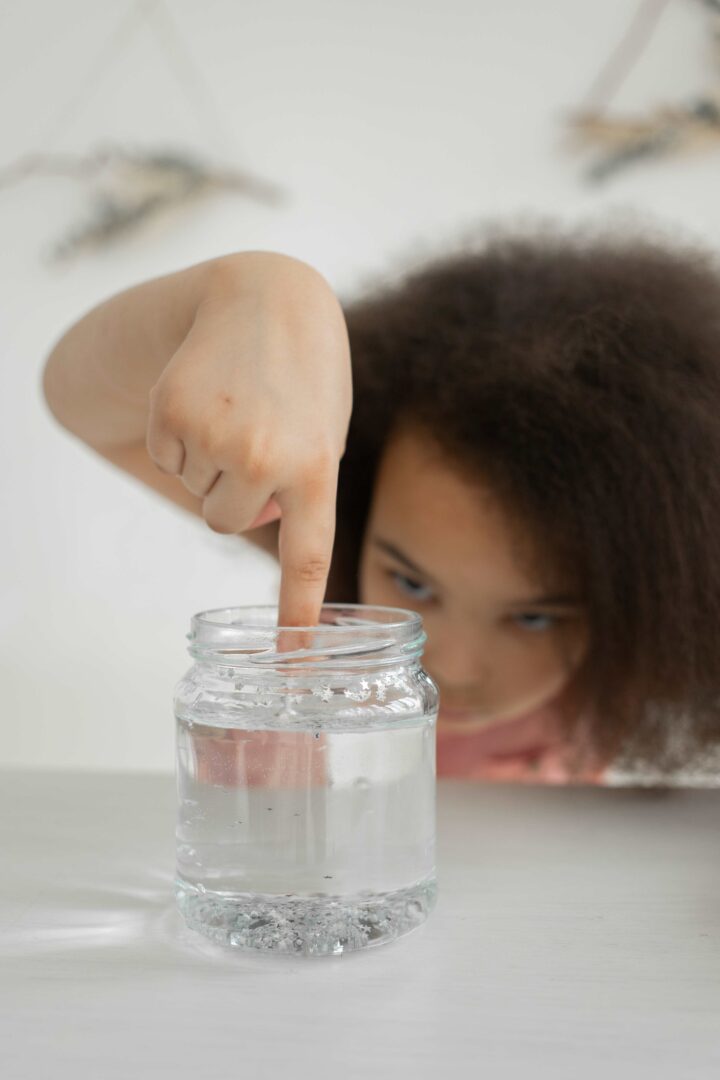 Girl with natural hair using clear gel to show DIY Styling Gel for Natural Hair: Gelatin