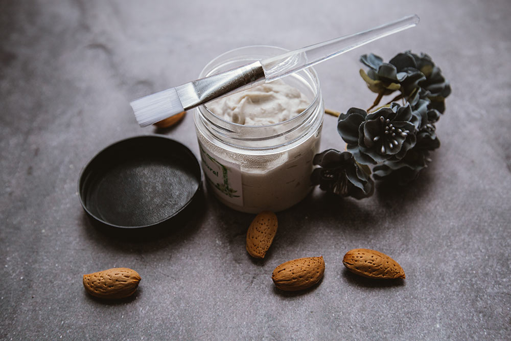 Clay treatment in a jar with an applicator showing how clay treatments and natural hair can improve your length goals.