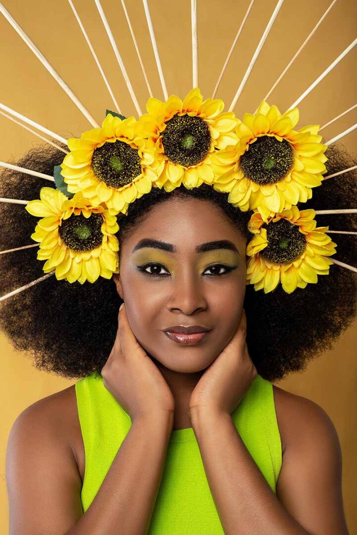 Woman with thick afro-textued hair with sunflowers in her hair