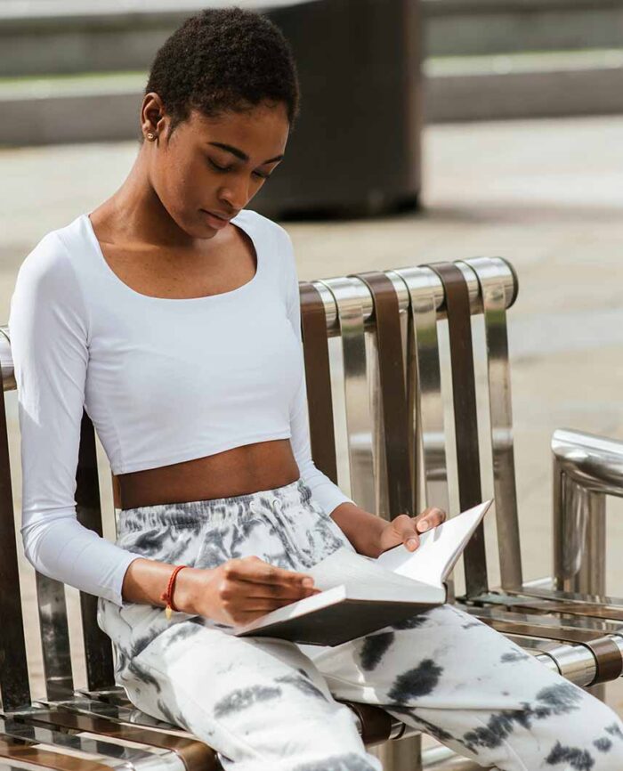 Girl with short afro reads on things she wishes she knew before starting her natural hair journey.