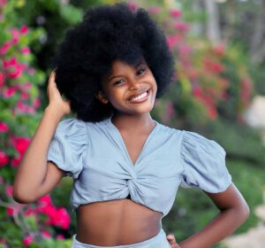 Close-up of a woman with healthy natural hair and a clean scalp, representing the foundation of a healthy scalp for hair growth.
